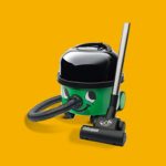 A green and black vacuum cleaner on a yellow background, perfect for all your vacuum cleaner repairs.