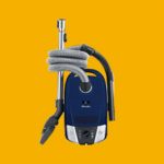 A blue vacuum cleaner on a yellow background specially designed for repairs.